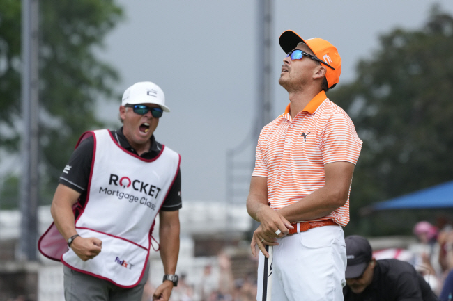 미국의 리키 파울러(오른쪽)가 3일 오전(한국시간) 미국 미시간주 디트로이트 골프클럽에서 열린 PGA투어 로켓 모기지 클래식 연장전 18번 홀에서 우승을 확정한 후 하늘을 바라보며 짧은 한숨을 내쉬고 있다. 환호성을 지르는 캐디와 대비돼 여운을 준다.  AP 연합뉴스