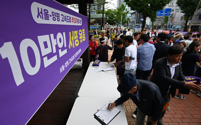10일 오전 경기 양평군청 광장에서 열린 ‘서울-양평 고속도로 사업 재개 범군민대책위원회 발대식’에서 참석자들이 고속도로 추진 재개를 위한 10만 인 서명운동에 참여하고 있다. 박윤슬 기자