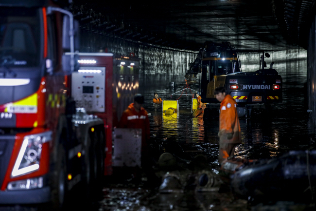 폭우로 미호강 제방이 유실돼 침수된 충북 청주시 흥덕구 오송읍 궁평 제2지하차도에서 17일 새벽 해양 경찰과 소방 등 구조대원들이 도보 수색을 하고 있다.  뉴시스