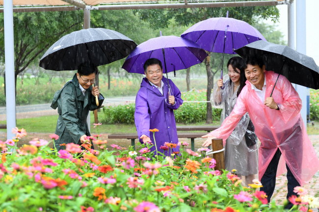 이필형(왼쪽 두 번째) 동대문구청장이 중랑천 장평교 일대에 조성한 백일홍정원을 지난 11일 방문, 활짝 핀 백일홍을 바라보며 환하게 웃고 있다. 동대문구청 제공