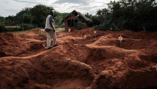 지난 4월 25일(현지 시간) 케냐 지방 도시 말린디에 있는 기쁜소식 국제교회 인근 샤카홀라 숲에서 현지 범죄수사대 한 수사관이 &quot;예수를 만나려면 굶어 죽어라&quot;는 사이비 종교 지도자의 강요에 숨진 신도들의 시신이 발굴된 집단 매장지 위를 걷고 있다. 7월 17일 12구의 시신이 추가로 발견되면서 지금까지 사망한 신도는 403명으로 늘었다. AFP·연합뉴스 자료사진