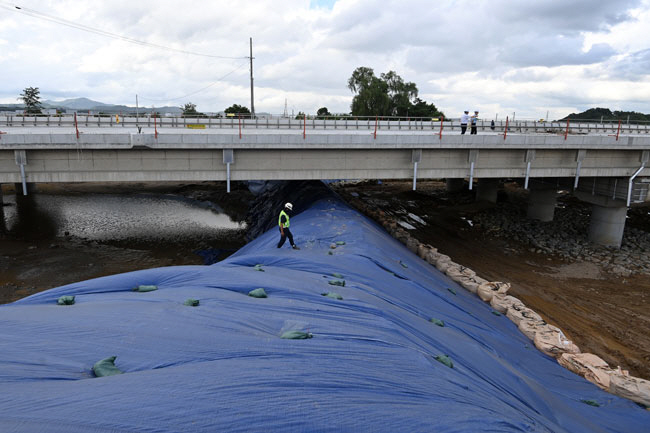 17일 충북 청주시 오송읍 궁평리 미호천교 아래에서 관계자들이 제방 보수작업을 하고 있다. 백동현 기자