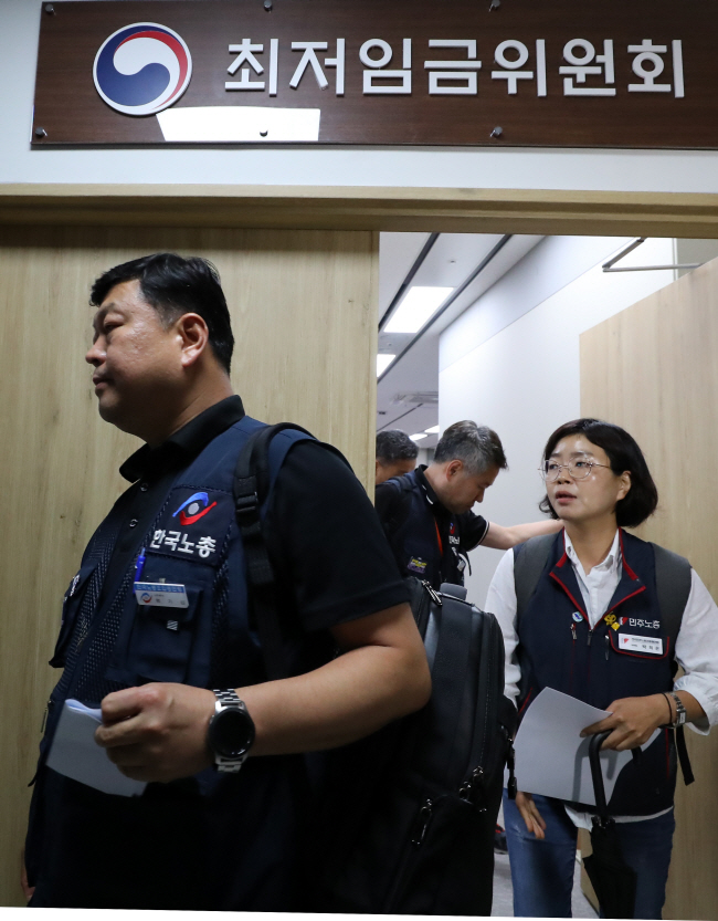 19일 오전 정부세종청사 최저임금위원회에서 근로자 위원인 류기섭(왼쪽) 한국노총 사무총장과 박희은(오른쪽) 민주노총 부위원장이 내년도 최저임금 결정 방식에 문제를 제기하면서 투표 결과를 확인하지 않은 채 퇴장하고 있다.  뉴시스