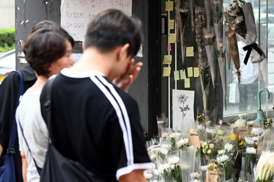 24일 오전 서울 관악구 신림역 인근 상가 골목에 마련된 흉기난동 사건으로 숨진 20대 남성을 추모하는 공간을 찾은 피해자의 대학 친구가 고인을 떠올리며 슬퍼하고 있다. 박윤슬 기자
