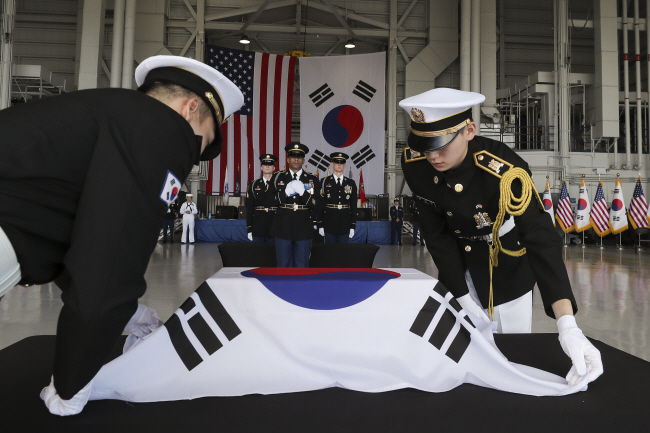 국군의장대가 25일 미국 하와이 히캄 공군기지에서 한·미 공동 ‘국군 전사자 유해 인수식’에서 유엔사로부터 인계받은 소관(작은 관)에 태극기 관포 의식을 진행하고 있다. 국방일보 제공