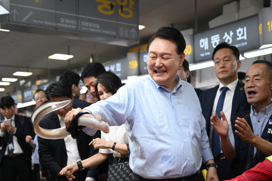 윤석열 대통령이 27일 부산 중구 자갈치시장을 방문해 붕장어를 잡아보고 있다. 대통령실 제공