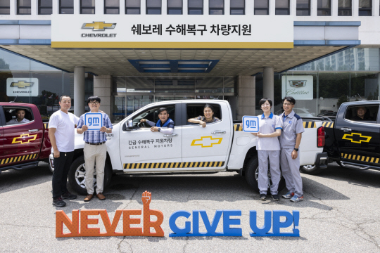GM 임직원들이 긴급구호 차량으로 지원하는 쉐보레 콜로라도 픽업트럭 앞에서 사진촬영을 하고 있다. 한국GM 제공