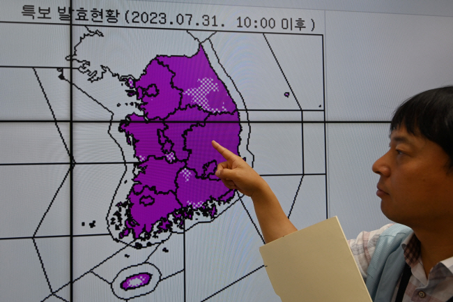 31일 오전 서울 동작구 기상청 정책브리핑실에서 한 통보관이 전국 대부분 지역에 내려진 폭염특보 발효 현황을 손가락으로 가리키고 있다. 문호남 기자