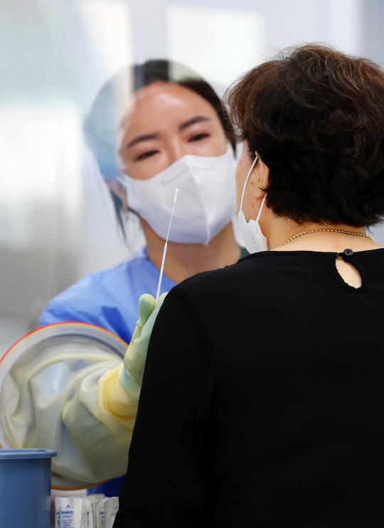 폭염 특보가 8일째 발효 중인 1일 오전 광주 서구보건소에 설치된 선별진료소에서 의료진이 코로나19 검체 채취를 하고 있다. 연합뉴스 제공