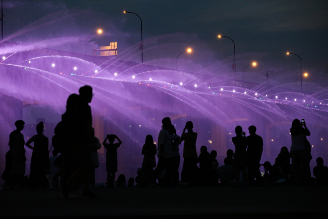 전국에 폭염특보가 닷새 연속 이어지고 있는 가운데 31일 오후 서울 서초구 반포한강공원에서 시민들이 반포대교 달빛무지개분수를 감상하며 열대야를 이겨내고 있다.  뉴시스