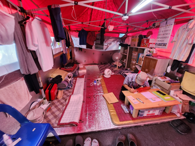 2일 오후 ‘판자촌’이 형성된 서울 강남구 개포동 ‘구룡마을’ 4지구 내 한 임시 천막 안에서 거주자가 선풍기 두 대에 의지해 더위를 나고 있다.