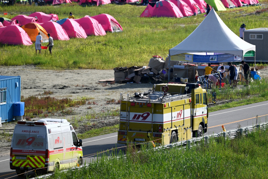수돗가에서 더위를 식히는 잼버리 참가자들 앞으로 소방차와 구급차가 이동하고 있다. 문호남 기자