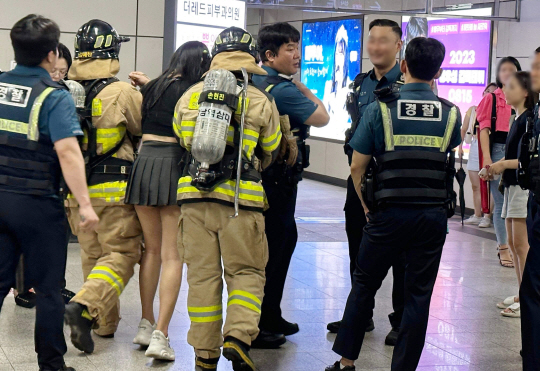 지난 6일 저녁 8시 36분쯤 서울 9호선 열차에서 흉기난동 및 생화학 테러 오인 신고가 연달아 접수돼 시민들이 신논현역에서 대피하는 소동이 빚어졌다. 사진은 6일 오인 신고로 신논현역에 출동한 경찰과 소방관들이 부상당한 시민을 부축하고 있다. 뉴시스(독자 제공)