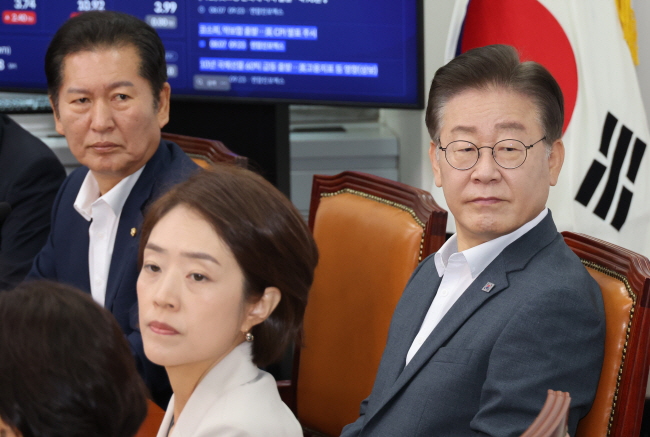여름휴가에서 복귀한 이재명(오른쪽) 더불어민주당 대표가 7일 오전 국회에서 열린 최고위원회에 참석해 정청래(왼쪽), 고민정(가운데) 최고위원과 ‘2023 새만금 세계스카우트 잼버리’ 대회 뉴스를 보고 있다.  연합뉴스