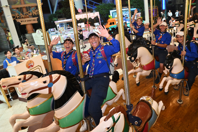 태풍 ‘카눈’의 영향으로 ‘2023 새만금 세계스카우트 잼버리’ 참가자들의 실외 활동이 전면 중단된 10일 오전 서울 송파구 롯데월드에서 멕시코 스카우트 대원들이 회전목마를 타고 있다.  백동현 기자