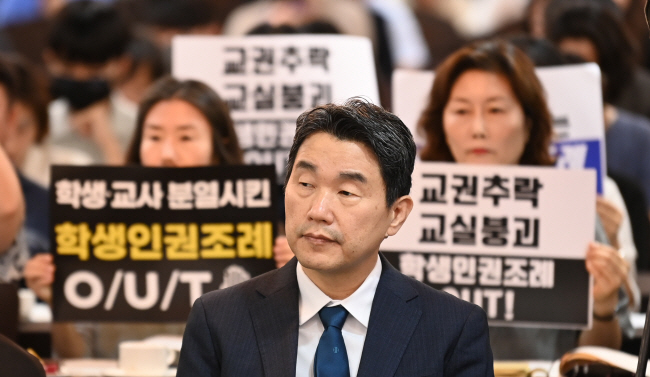 10일 오전 서울 중구 코리아나 호텔에서 열린 ‘교권보호 강화 방안 관련 교육개혁 대토론회’에서 학생인권조례를 반대하는 서울교육사랑전국학부모연합 회원들이 이주호 교육부 장관을 앞에 두고 피켓을 들고 시위하고 있다.     박윤슬 기자