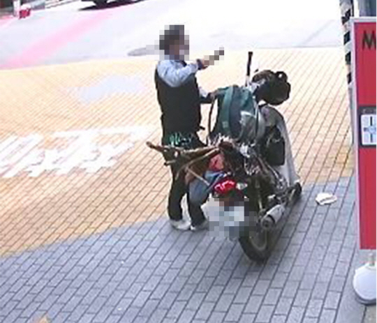 지난 8일 대구 수성구 학원가에서 40대 남성이 오토바이에 보관하고 있던 흉기를 빼내 들고 있다. 대구경찰청 제공