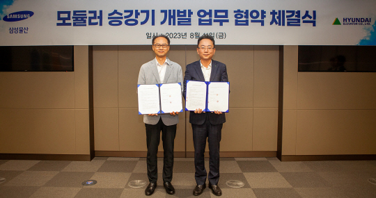 이태원(오른쪽) 현대엘리베이터 CTO가 지난 11일 서울 강동구 삼성 글로벌 엔지니어링센터에서 조인수 삼성물산 M&E 본부장과 업무협약 체결식을 마친 후 기념 촬영을 하고 있다. 현대엘리베이터 제공