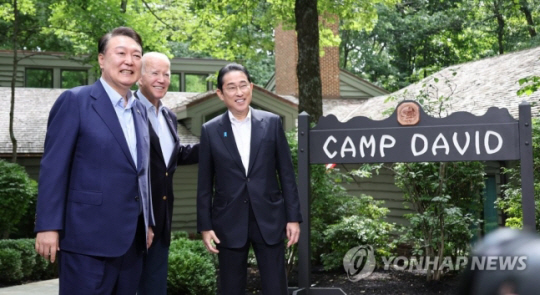 윤석열 대통령과 조 바이든 미국 대통령, 기시다 후미오 일본 총리가 18일(현지시간) 워싱턴DC 인근 미국 대통령 별장인 캠프 데이비드에서 열린 한미일 정상회의를 앞두고 로렐 로지 앞에서 기념 촬영을 하고 있다. 연합뉴스