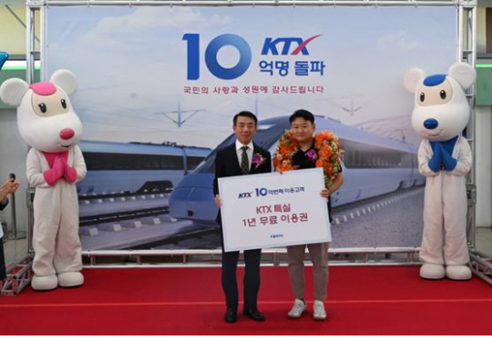 한문희(왼쪽) 코레일 사장이 지난 31일 서울역에서 열린 ‘KTX 이용객 10억 명 돌파 기념 행사’에서 10억 번째 고객 장재화 씨에게 ‘KTX특실 1년 무료 이용권’을 전달하고 있다. 코레일 제공