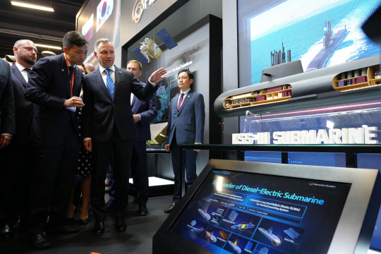 김동관(왼쪽 두번째) 한화에어로스페이스 부회장이 5일(현지시각) 폴란드 MSPO 방산전시회에서 한화오션 부스를 찾은 안제이 두다 (왼쪽 세번째) 폴란드 대통령(왼쪽 세 번째)에게 한화오션의 3000t급 잠수함 ‘장보고-III 배치(Batch)-II’ 모형을 보여주며 잠수함 기술력에 대해 설명하고 있다. 한화에어로스페이스 제공