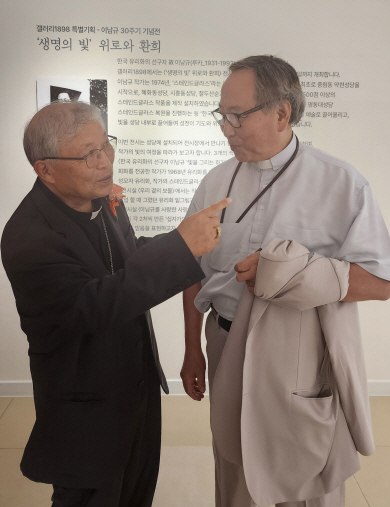 염수정(왼쪽) 추기경이 ‘유리화 작가 이남규 30주기 특별전’에서 조광호 신부와 대화를 나누고 있다.