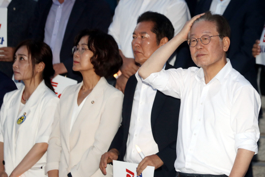 8일 오후 서울 여의도 국회 본청 앞 계단에서 단식 9일째에 들어간 이재명(오른쪽) 더불어민주당 대표가 제6차 윤석열 정권 폭정 저지·민주주의 회복 촛불 문화제에 참석해 손으로 머리를 넘기고 있다. 뉴시스