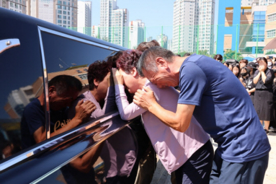 악성 민원으로 세상을 뜬 대전 초등 교사의 운구 차량이 9일 오전 교사가 재직하던 유성구 한 초등학교에 들러 마지막 인사를 하자, 유족들이 운구 차량에 기대 오열하고 있다. 연합뉴스