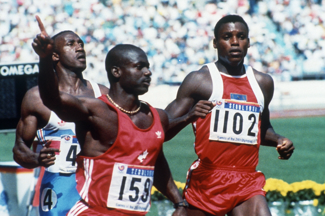 1988년 서울올림픽 남자 육상 100m 결승에서 손을 치켜드는 여유를 보이며 1위로 골인한 캐나다의 벤 존슨(왼쪽)과 2위로 들어온 미국의 칼 루이스(오른쪽). AP 연합뉴스