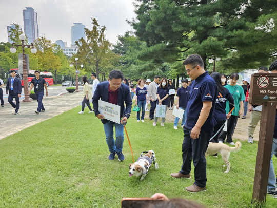 ‘개 식용 금지법’을 발의한 이헌승 국민의힘 의원이 19일 국회 경내에서 열린 ‘개 농장 구조견과 함께 하는 산책 : 꽃길’ 행사에서 강아지와 함께 산책하고 있다. 이 의원실 제공.