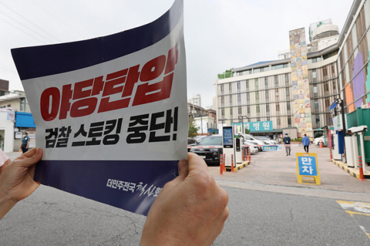 19일 이재명 더불어민주당 대표가 병상 단식을 이어가고 있는 서울 중랑구 사가정로 녹색병원 앞에서 한 지지자가 손팻말을 들고 있다. 연합뉴스