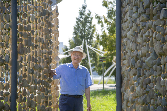 윤영달 크라운해태제과 회장이 지난 8일 서울 성동구 뚝섬한강공원에서 진행 중인 ‘2023한강조각프로젝트’에 전시된 이재효 작가의 작품 0121-1110=123091 사이에서 미소 짓고 있다. 크라운해태 제공
