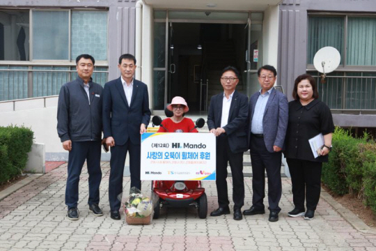 HL만도와 한국교통안전공단 관계자들이 지원 사업에 선정된 가정을 방문해 휠체어를 전달하고 있다. 한국교통안전공단 제공