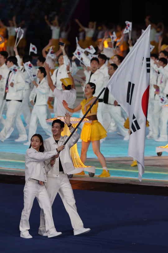 대한민국 선수단의 공동기수 구본길(오른쪽)과 김서영이 23일 중국 저장성의 성도 항저우시 올림픽 스포츠센터 스타디움에서 열린 2022 항저우아시안게임 개회식에서 태극기를 들고 입장하고 있다. 뉴시스