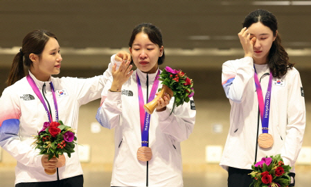 이계림(왼쪽부터), 이은서, 배상희가 27일 중국 항저우 푸양 인후 스포츠센터에서 열린 항저우아시안게임 여자 50m 소총 3자세 단체전 시상식에서 눈물을 훔치고 있다. 연합뉴스