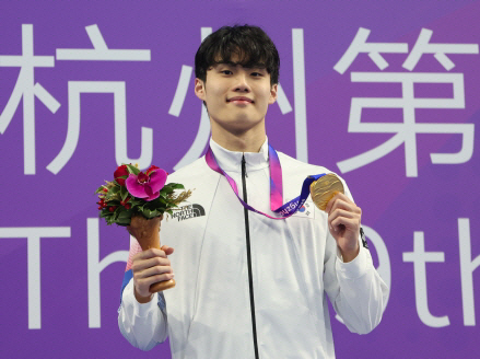황선우가 27일 중국 저장성 항저우 올림픽 스포츠센터 수영장에서 열린 항저우아시안게임 남자 자유형 200m 시상식에서 ‘금메달 포즈’를 취하고 있다. 연합뉴스