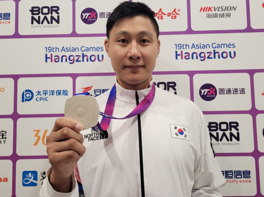 김민규가 2일 중국 항저우의 샤오산 린푸 체육관에서 2022 항저우아시안게임 쿠라시 남자 90㎏이하급에서 획득한 은메달을 든 채 포즈를 취하고 있다. 연합뉴스