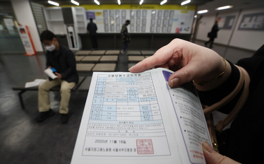 직장을 잃은 한 시민이 고용보험수급자격증을 들어보이고 있다. 뉴시스