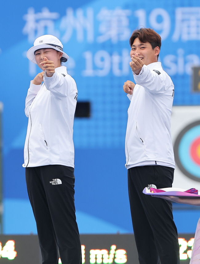 임시현(왼쪽)과 이우석이 4일 중국 항저우 푸양 인후 스포츠센터에서 열린 항저우아시안게임 양궁 리커브 혼성전 메달 수여식에서 하트를 쏘는 세리머니를 하고 있다.  연합뉴스