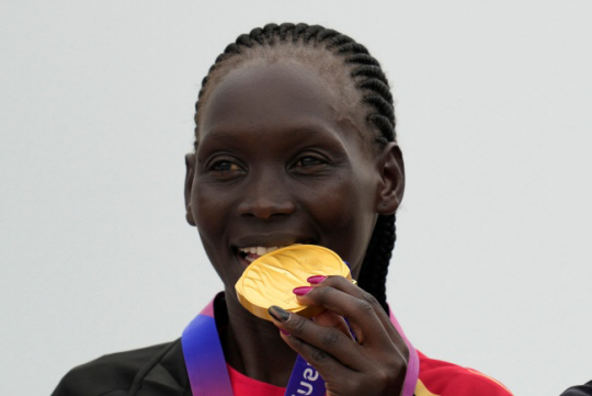 바레인의 유니스 춤바가 5일 중국 저장성 항저우 일원에서 열린 2022 항저우아시안게임 여자 마라톤에서 금메달을 목에 건 뒤 메달을 깨무는 세리머니를 하고 있다. AP뉴시스