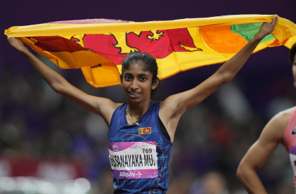 스리랑카의 다루시 디사나야카 무디얀셀라지가 지난 4일 열린 항저우아시안게임 육상 여자 800m에서 우승한 뒤 ‘국기 세리머니’를 펼치고 있다. AP 뉴시스