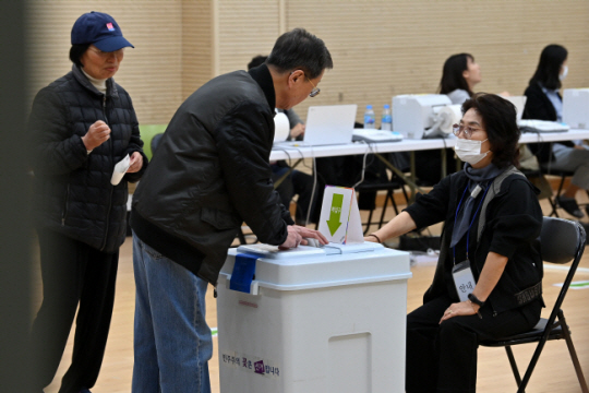 서울 강서구청장 보궐선거 사전투표 첫날인 6일 오전 서울 강서구 방화1동 주민센터에 마련된 투표소에서 유권자들이 투표한 용지를 기표함에 넣고 있다. 문호남 기자