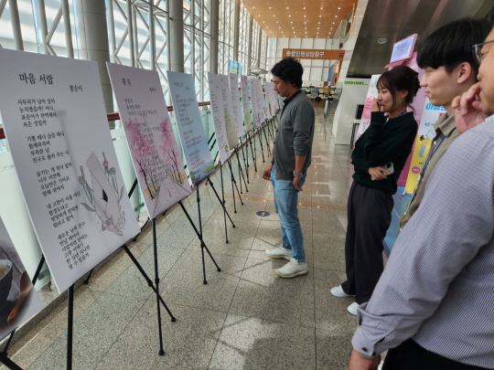 10일 오후 정오쯤 경기 용인시 처인구 삼가동 시청 1층에서 열린 시화전이 열리자 관람객들이 작품을 감상하고 있다. 용인=박성훈 기자