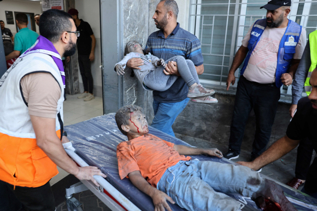 10일 이스라엘이 팔레스타인 무장정파 하마스가 통치하고 있는 가자지구 지역을 공습한 이후 구조대원들이 다친 어린이들을 병원으로 호송하고 있다.   AFP 연합뉴스