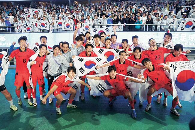 축구대표팀 선수들이 지난 7일 항저우아시안게임 남자축구 일본과의 결승전에서 우승한 후 태극기를 펼친 채 환호하고 있다.연합뉴스