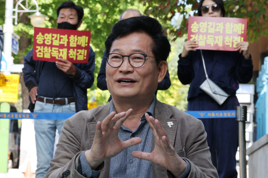 송영길 전 더불어민주당 대표가 지난 11일 오전 서울 서초구 중앙지검 앞에서 검찰 규탄 농성을 하던 도중 지지자의 질문에 답하고 있다. 연합뉴스