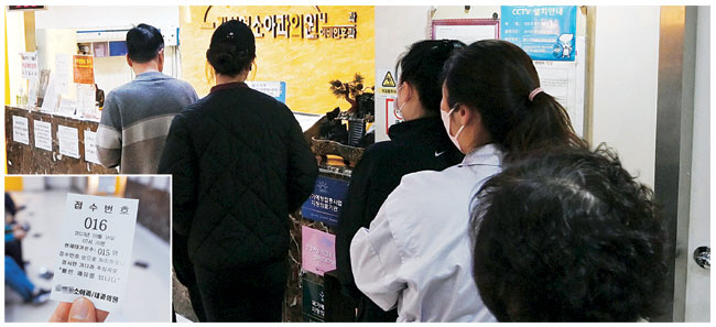 18일 오전 서울 성북구 한 소아청소년과에 시민들이 자녀의 진료를 위해 접수 창구에 줄지어 서 있다. 작은 사진은 소아 진료를 받기 위해 이른 아침부터 기다려서 뽑은 대기 번호표.  문호남 기자