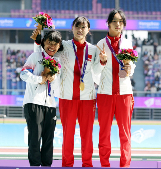 전민재(사진 왼쪽)가 23일 중국 저장성 항저우 올림픽 스포츠센터 주경기장에서 열린 2022 항저우 장애인아시안게임 육상 여자 T36 200m에서 은메달을 목에 걸고 시상대에 올랐다. 대한장애인체육회 제공