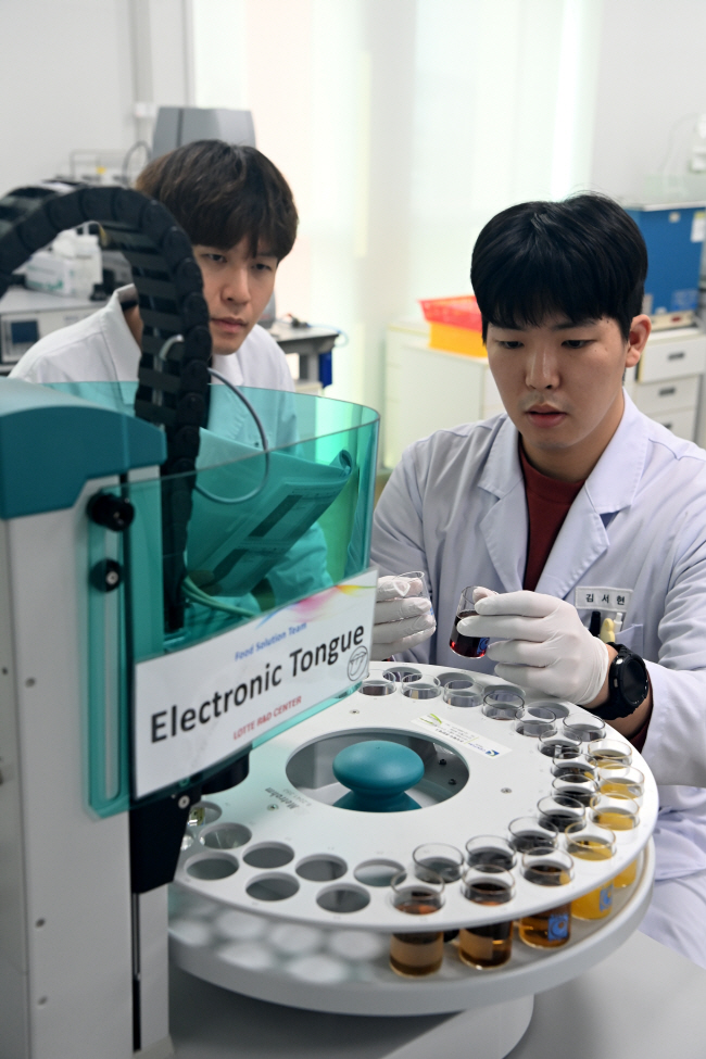 롯데중앙연구소 연구원이 관능 검사 기계인 ‘전자혀’로 위스키, 와인 시제품들의 맛 데이터를 측정하고 있다.  곽성호 기자