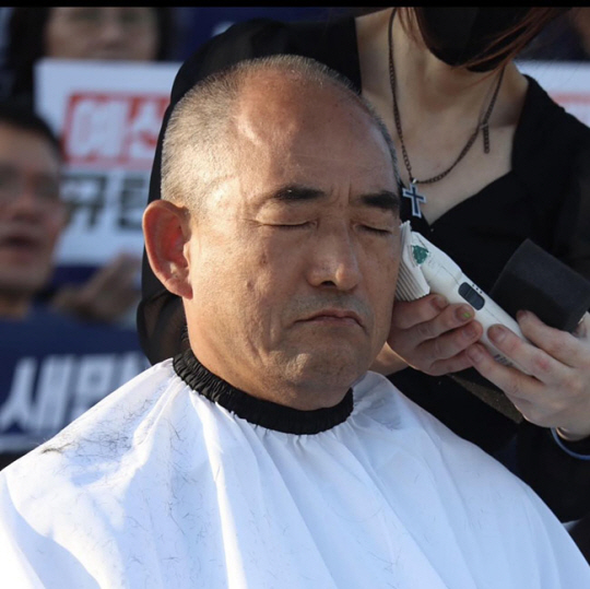 국회 앞에서 삭발을 하고 있는 윤준병 민주당 의원.